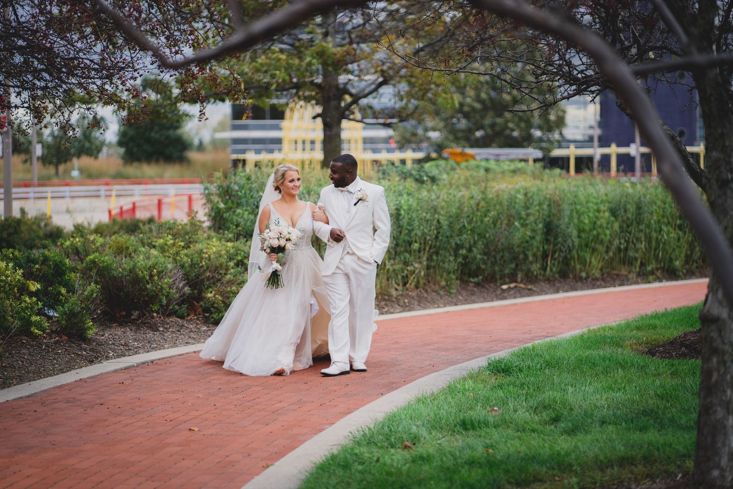 Wedding ceremony setup on a brick pathway surrounded by landscaped gardens.