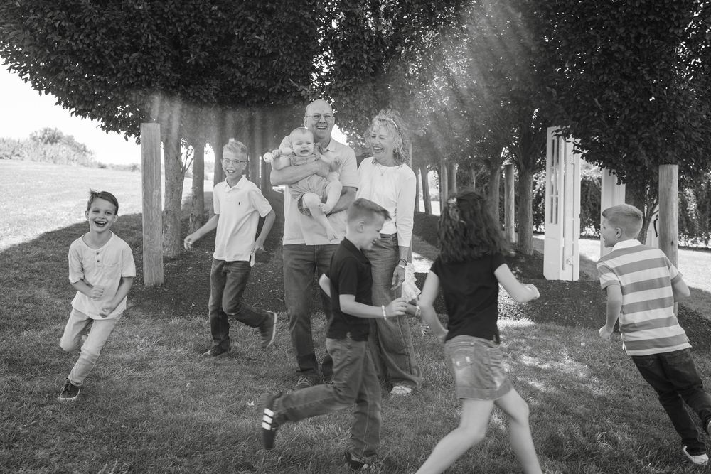 Laughing children running around grandparents in a warm family moment