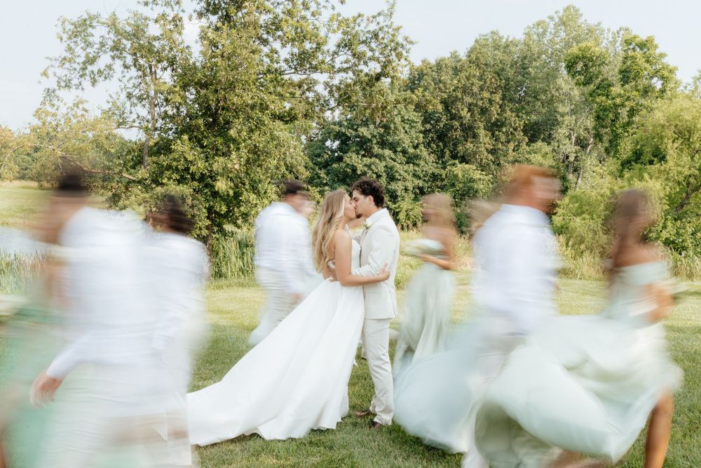 Ethereal motion blur of white dresses against a green outdoor backdrop.