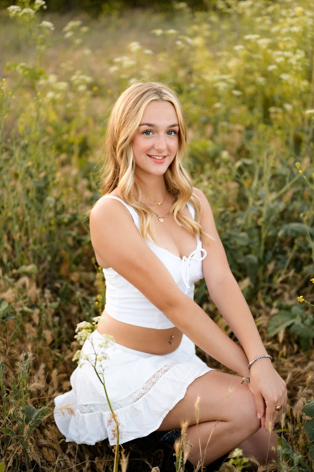 Ojai River Preserve high school senior portraits of girl in white two piece dress in flowers by Ventura and Santa Barbara photographer
