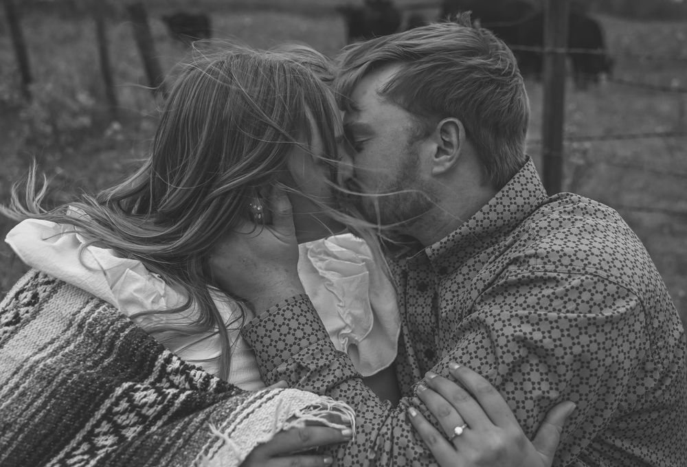 A romantic black and white photo series showing a couple embracing and kissing in various intimate poses.
