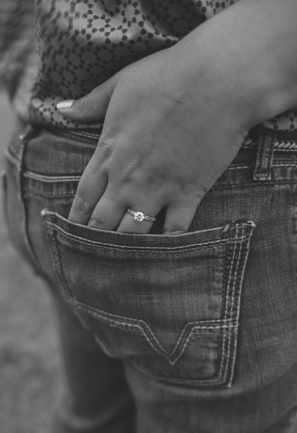 Close-up black and white shot of hands in denim jeans pockets showing casual style.