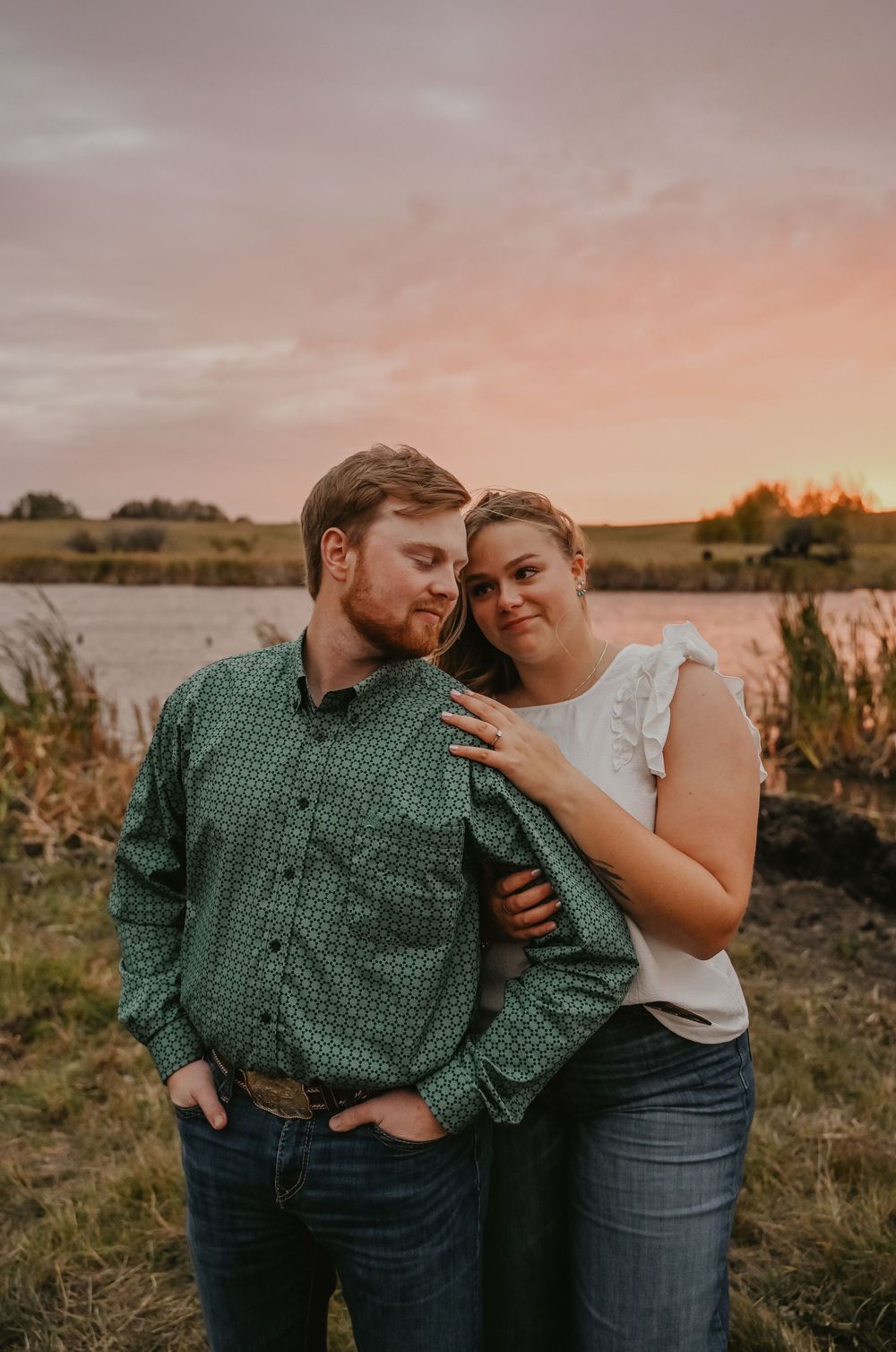 An intimate couple embraces while sharing tender moments in a rustic outdoor setting at dusk.