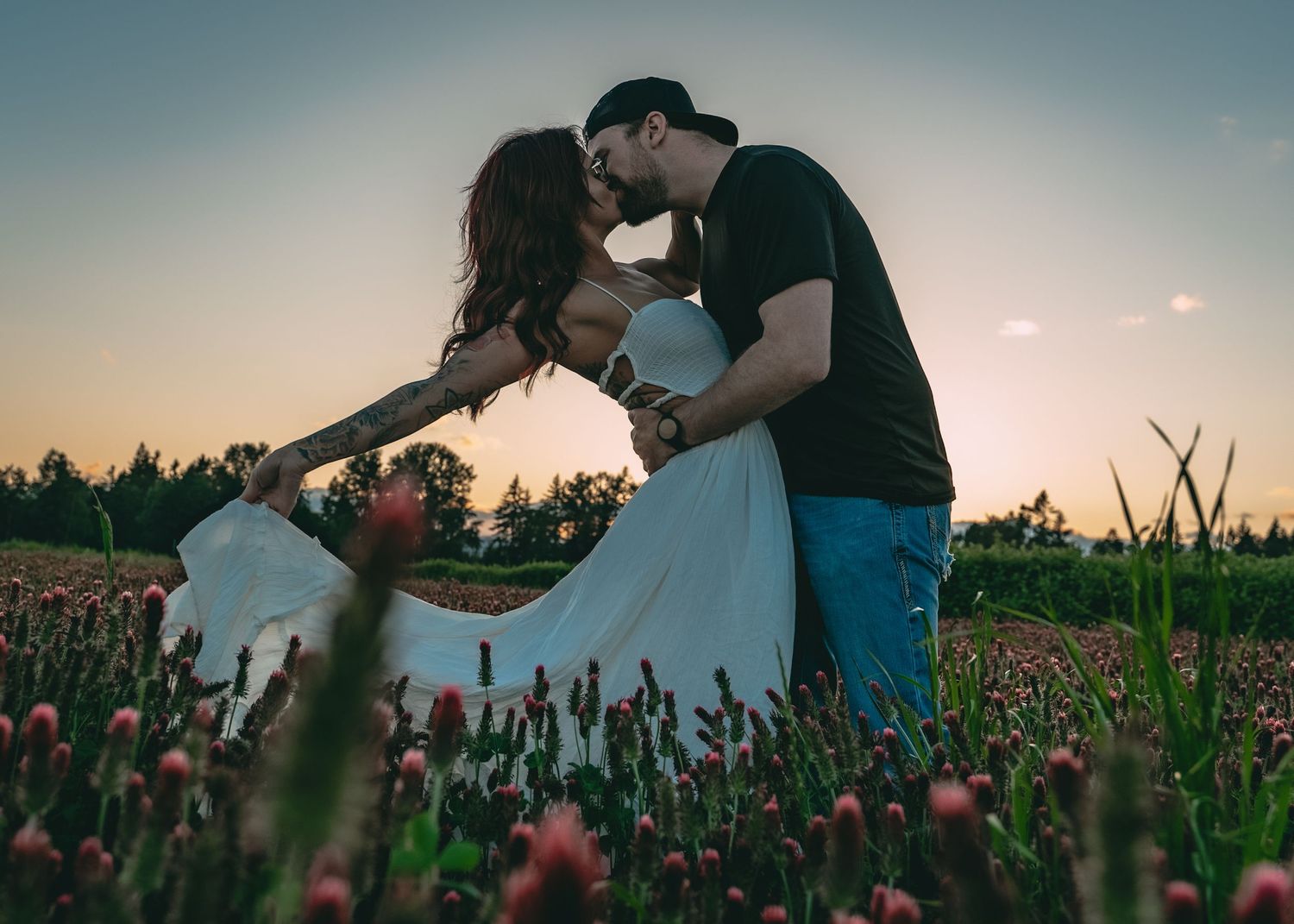 Romantic sunset portrait in field of wildflowers during golden hour.
