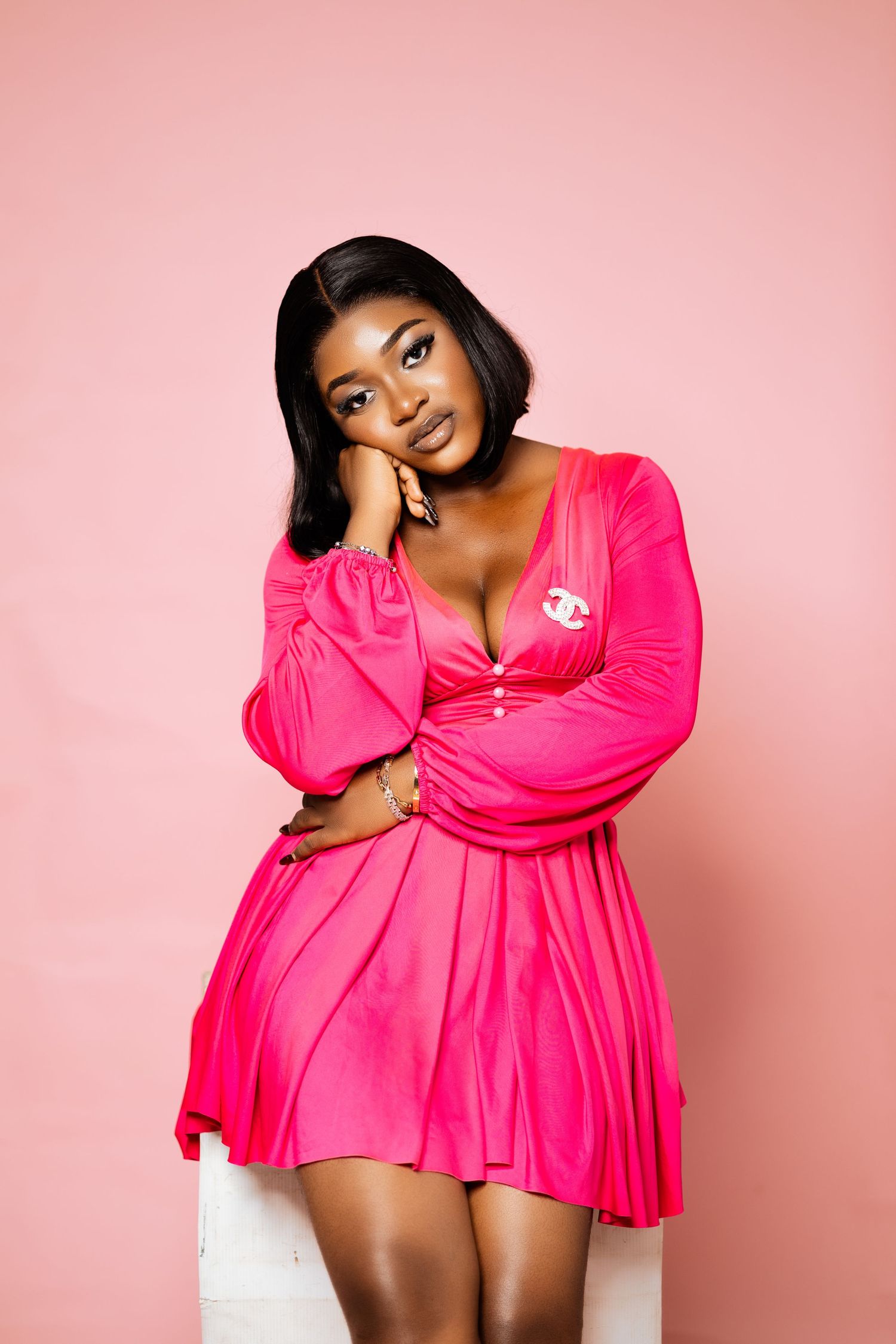 Fashion portrait in bright pink dress against pink background.