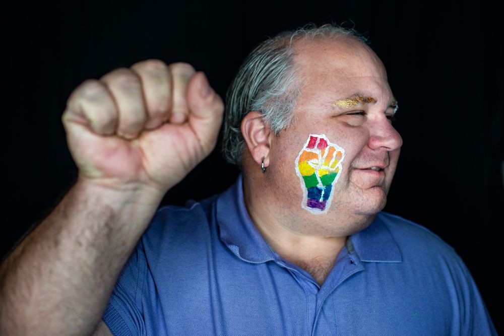 Person in blue shirt showing a series of hand gestures against dark background.