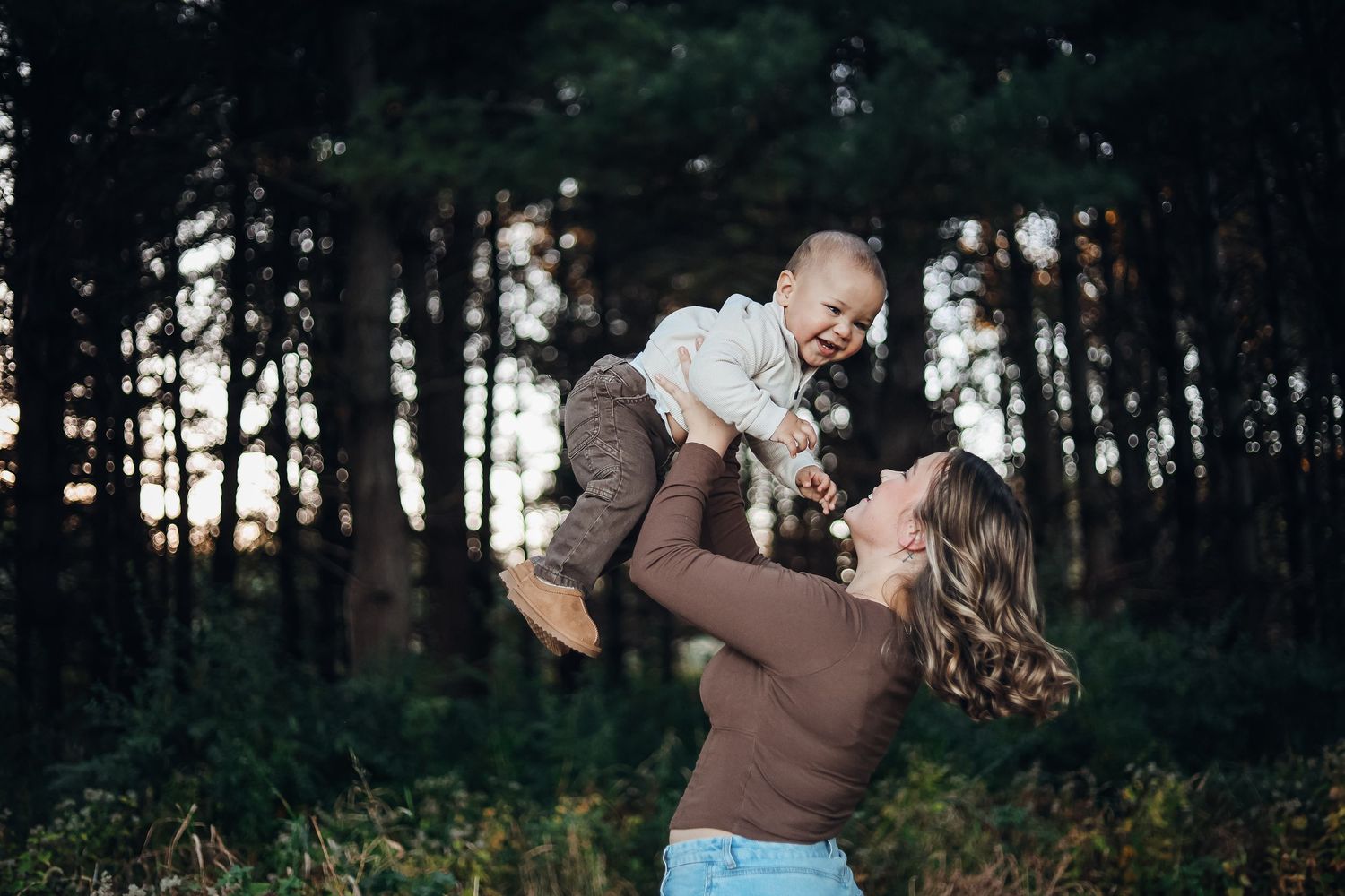 Playful outdoor photoshoot in a forest setting during golden hour. Example of family photography sessions