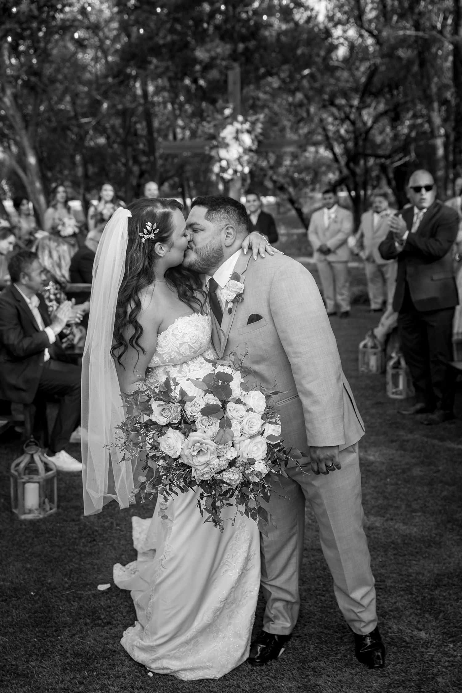 Black and white wedding photos showing romantic moments between newlyweds in an outdoor garden setting.
