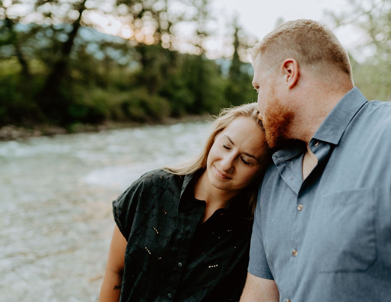 Intimate couple's portrait captured by a rushing river at sunset.