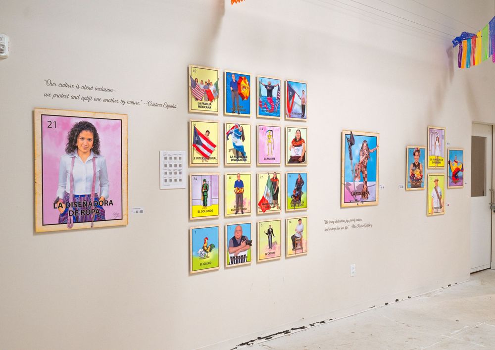 Colorful children's artwork displayed in a gallery setting with white walls and evenly spaced framed pieces.