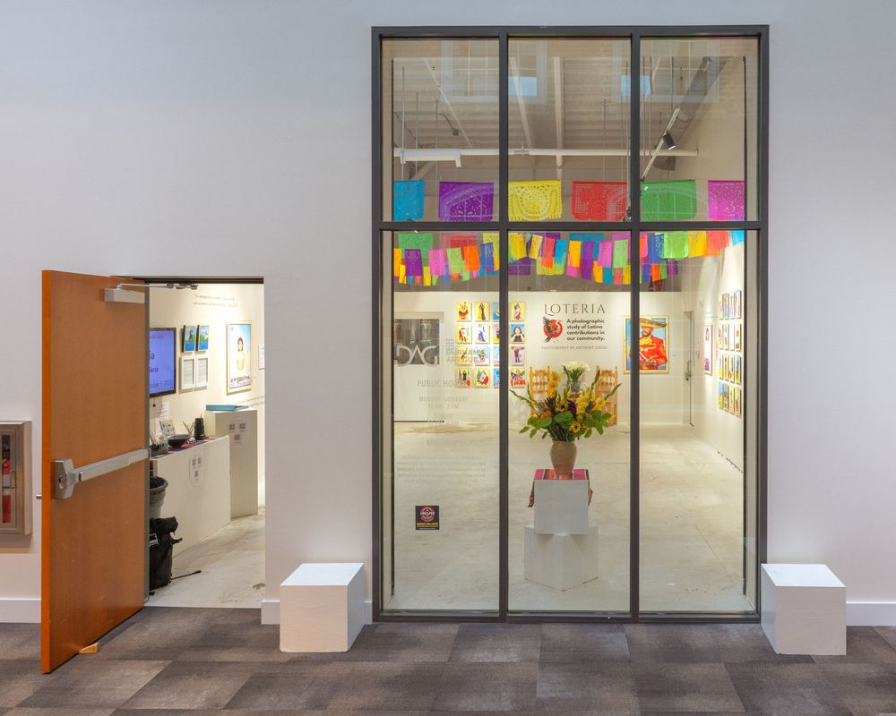 Glass office entrance with colorful paper decorations and a vase of flowers displayed in the window.