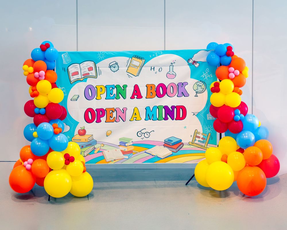 Colorful balloon arch display with 'Open a Book' and 'Open a Mind' text banners for library or school decoration.