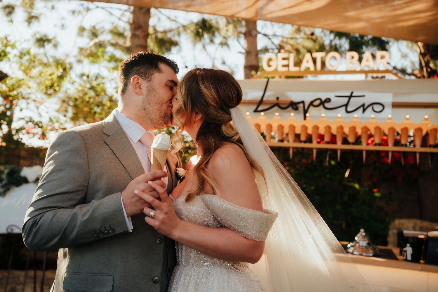 Newlyweds share champagne toast against a decorative geometric backdrop.