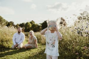 Family enjoying a sunny afternoon in a meadow during golden hour.