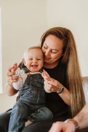 Tender indoor moment between parent and child in denim overalls.