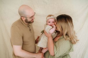 Intimate family portrait session with neutral tones against white background.
