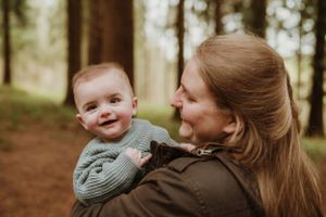 A joyful outdoor portrait in a forest setting with warm autumn colors.