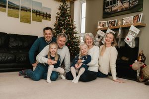 A series of candid family photos arranged in a horizontal collage with a Christmas tree visible in multiple shots.