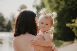 A parent and baby share tender moments together outdoors in a series of connected lifestyle photos.