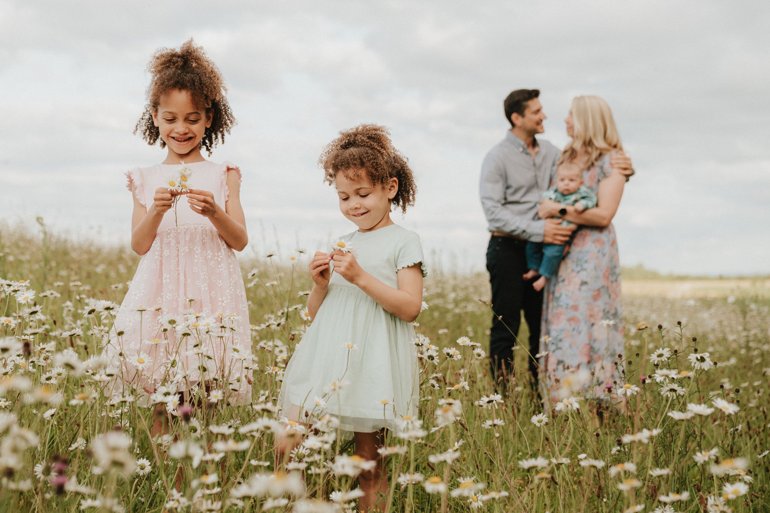 Children playing together in a sunny wildflower meadow during golden hour.