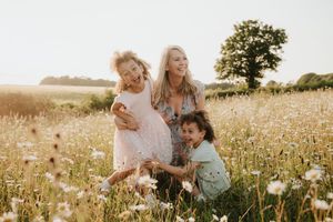 Family spending quality time together in a sunlit meadow filled with wildflowers.