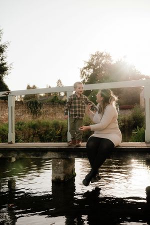 A couple sits on a wooden dock at sunset, creating a romantic silhouette against the shimmering water.