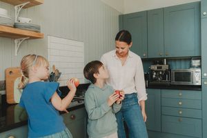 A series of photos showing a family baking together in a teal-colored kitchen, mixing ingredients and sharing moments.