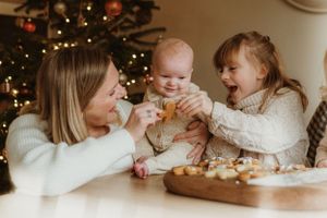 Family gathered around a table decorating holiday cookies together in warm lighting.
