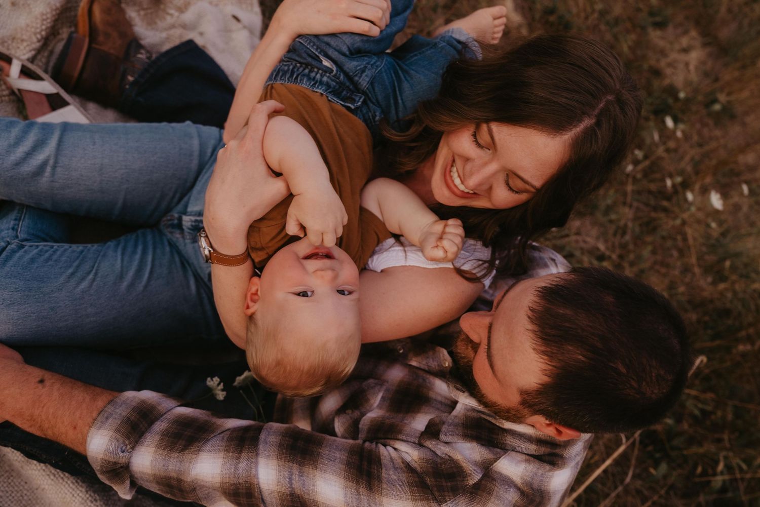 Happy family of four posing together on wooded trail.