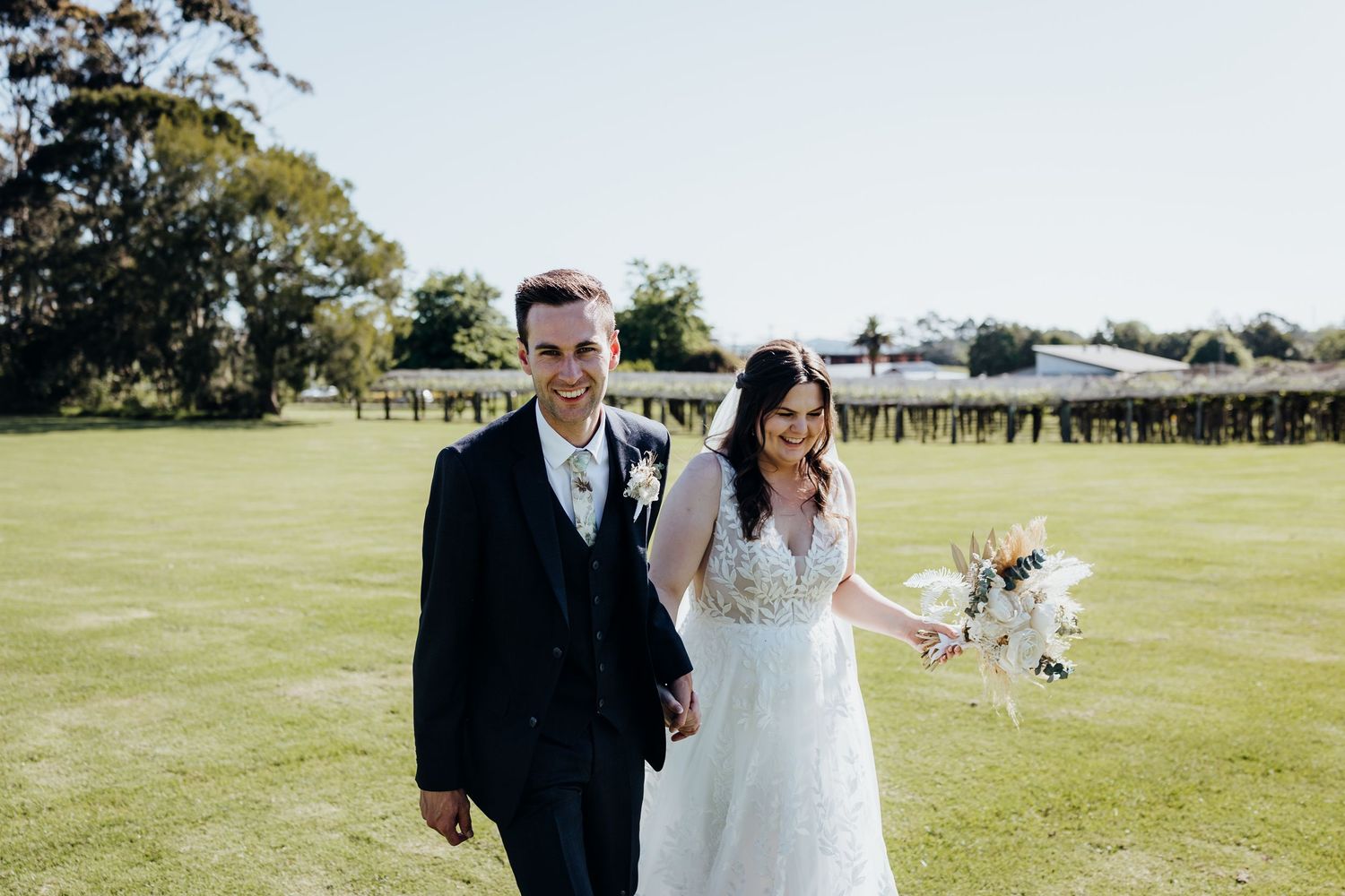 A photo series from a wedding celebration on a sunny day in an open grassy field with trees in the background.