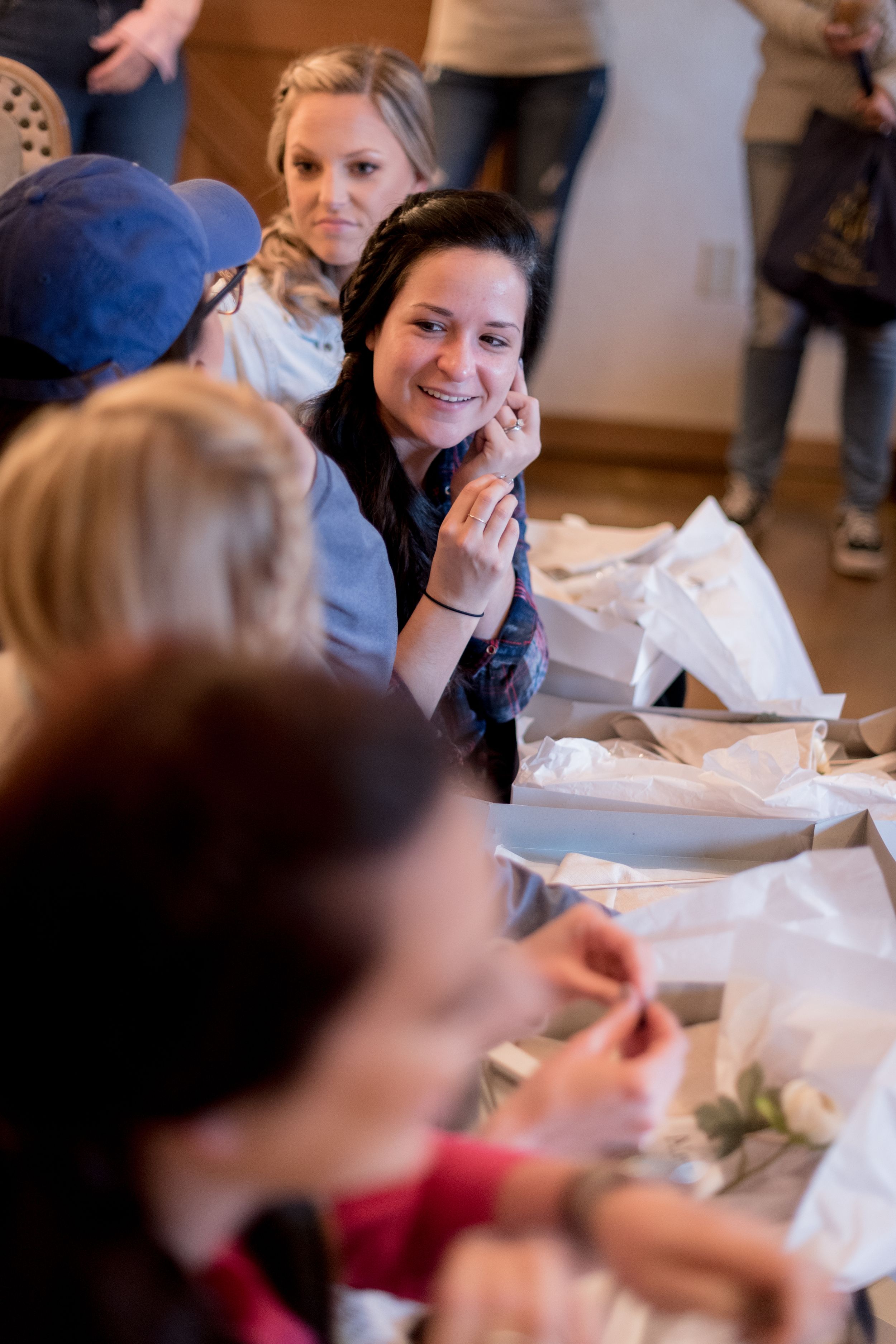 Group gathered around a table during wedding preparation activities.