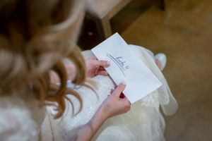 Close-up view of hands writing in a wedding day journal or letter.