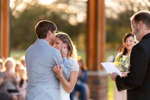 Couple embraces during emotional outdoor wedding ceremony.