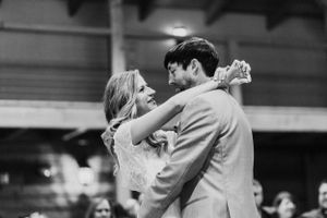A couple shares their first dance at a wedding reception in black and white.
