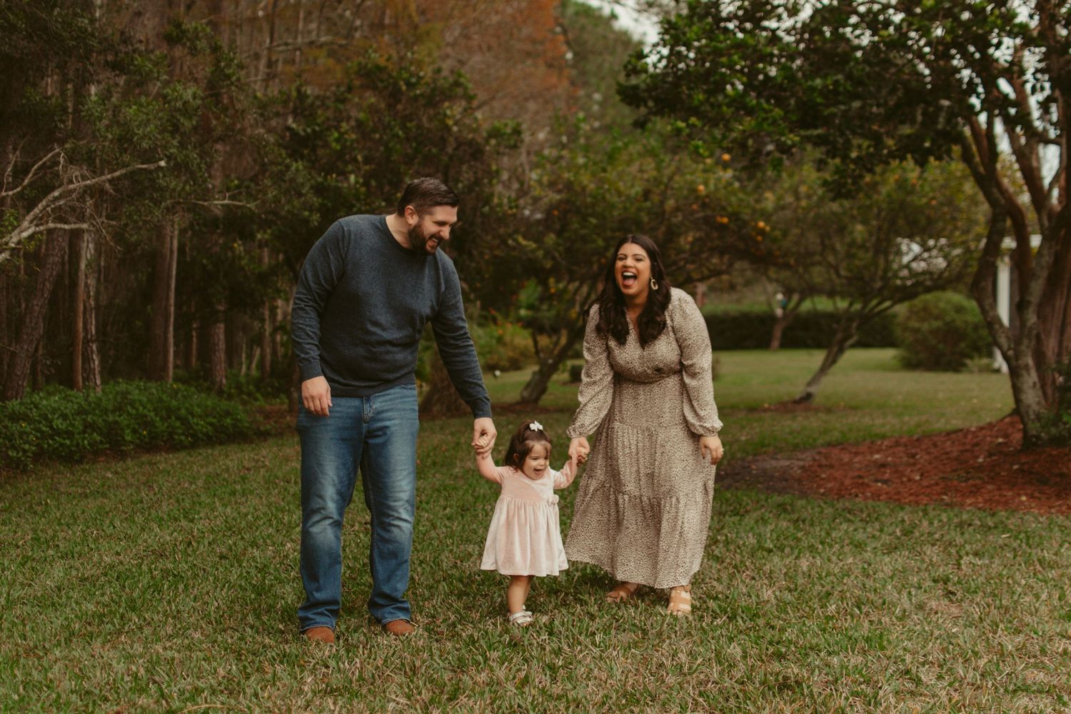 Family walking together through a lush green park setting.
