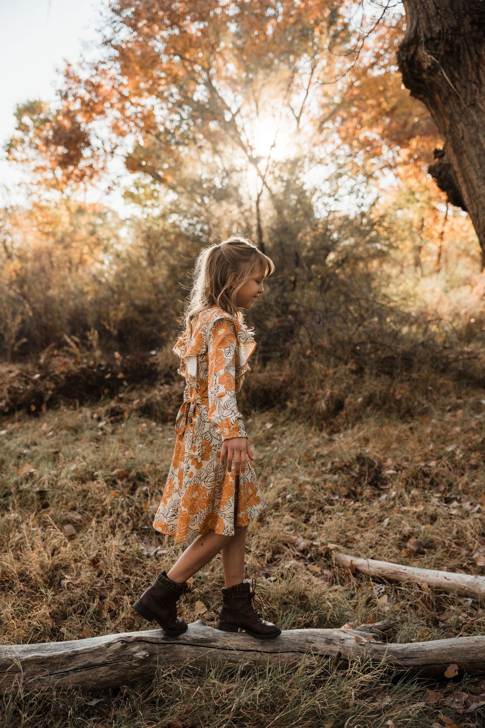 Series of outdoor portraits featuring child on fallen log in autumn setting.