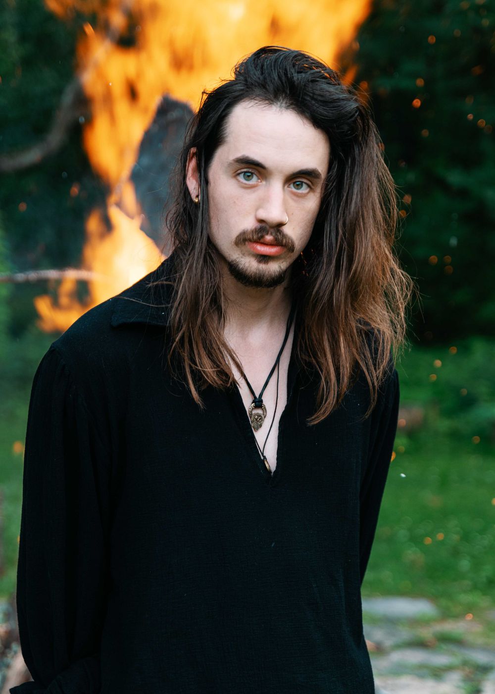 Portrait of man standing in front of fire.
