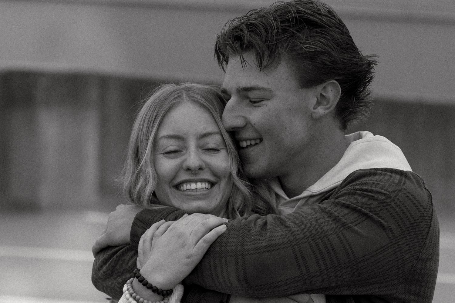 A romantic black and white photograph showing an intimate embrace filled with joy and laughter.