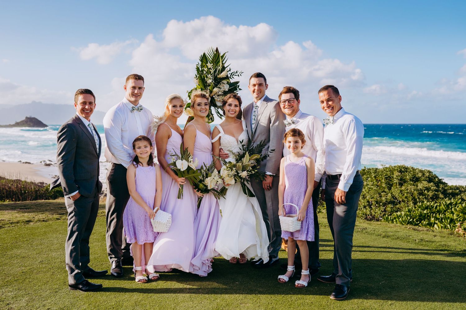 Wedding couple sharing a kiss as flower petals fall around them in a garden setting. best hawaii family photographer kihei wailea kaanapali