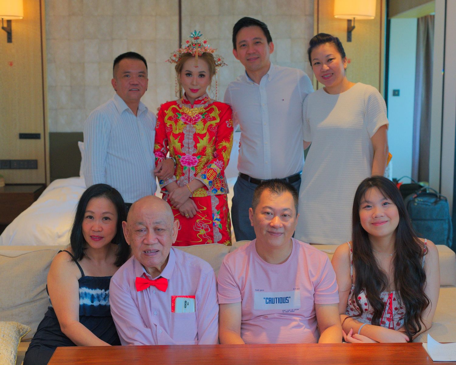 A group photo of wedding guests and family members in formal attire.