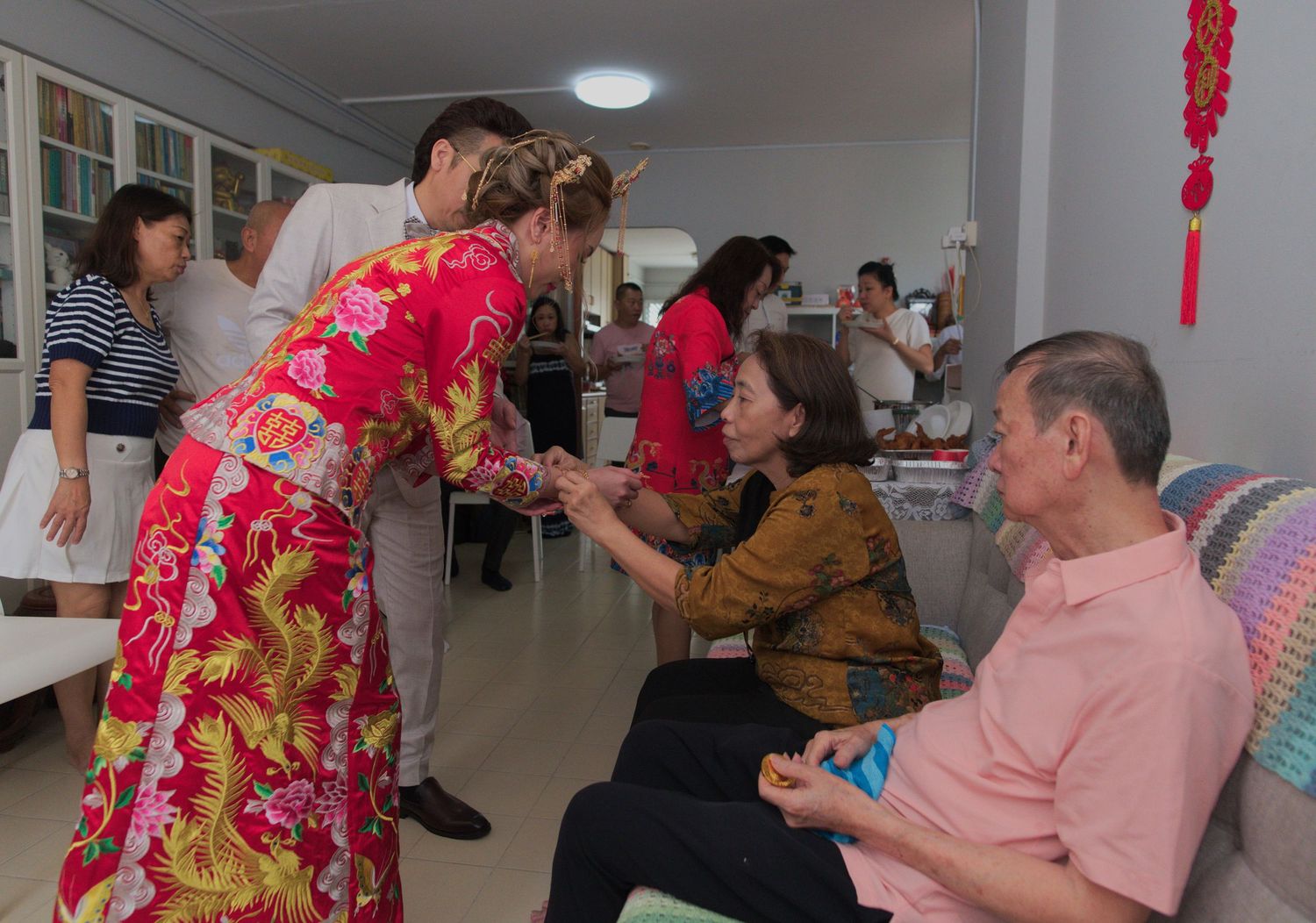 Wedding celebration scene in a room with traditional decorations and festivities.