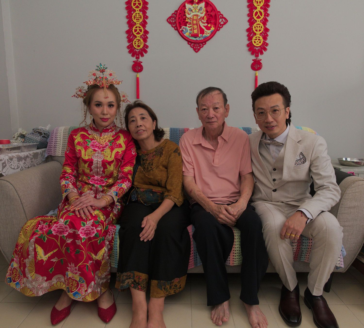 Family gathering in a room decorated with traditional Chinese red ornaments and lanterns.