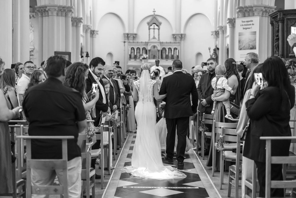 Black and white photograph of a traditional church wedding ceremony with guests seated in wooden pews.