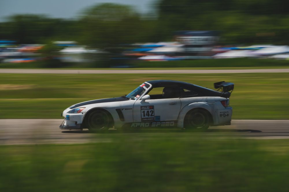 White racing car in motion on track with motion blur effect.