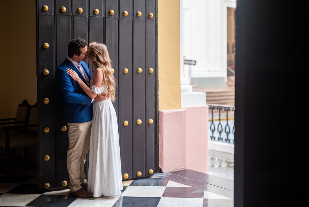 A romantic moment captured against an ornate black door with gold accents.