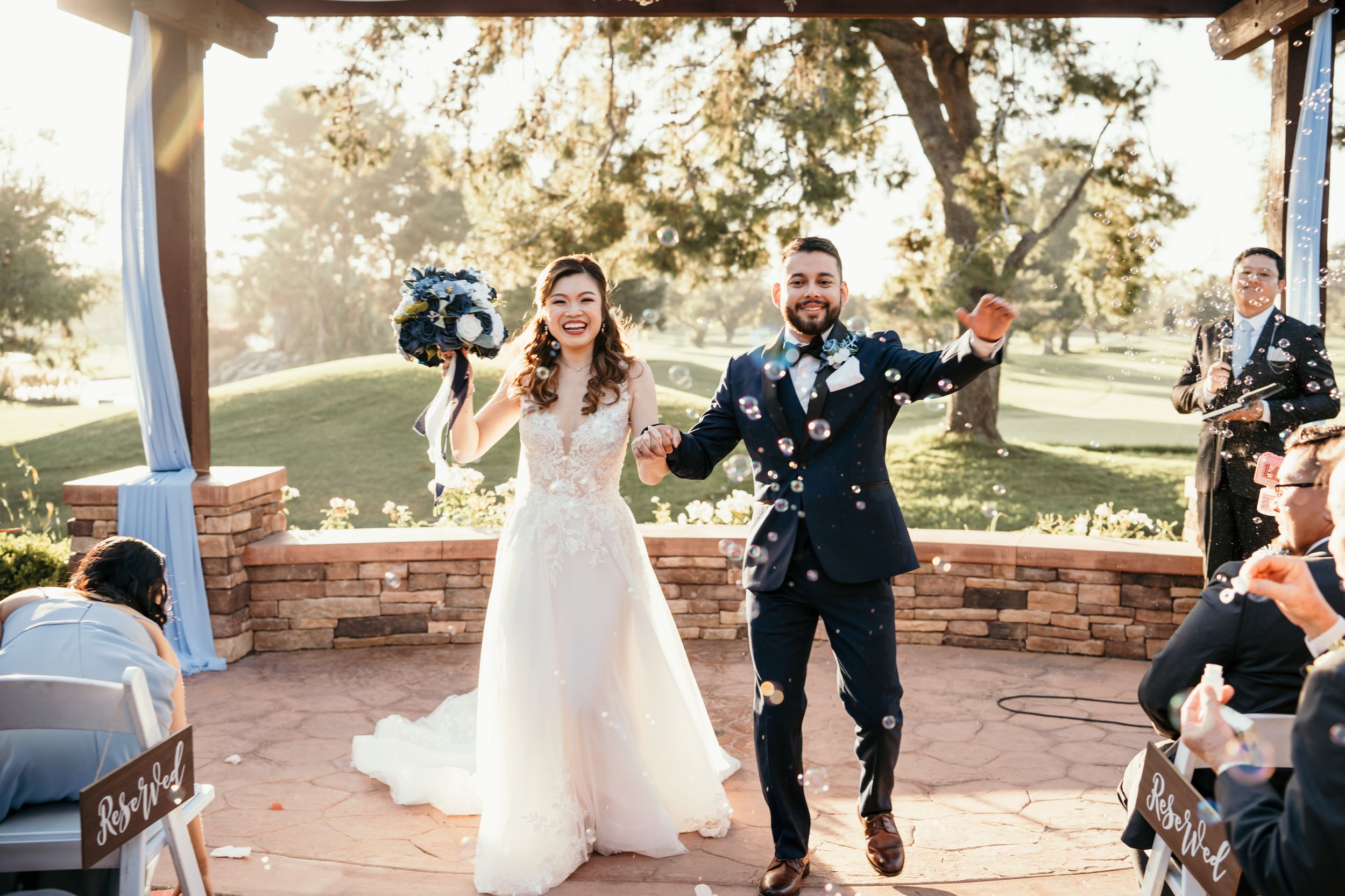Joyful celebration moment at outdoor wedding ceremony with confetti in the air.