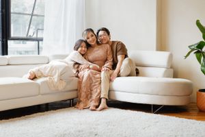 Cozy family moment on sectional white sofa in bright modern living room.