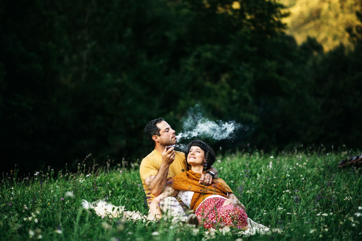 Photography photo of a couple outside of Vicenza, Italy. He let's smoke out of his mouth as she stares at him.