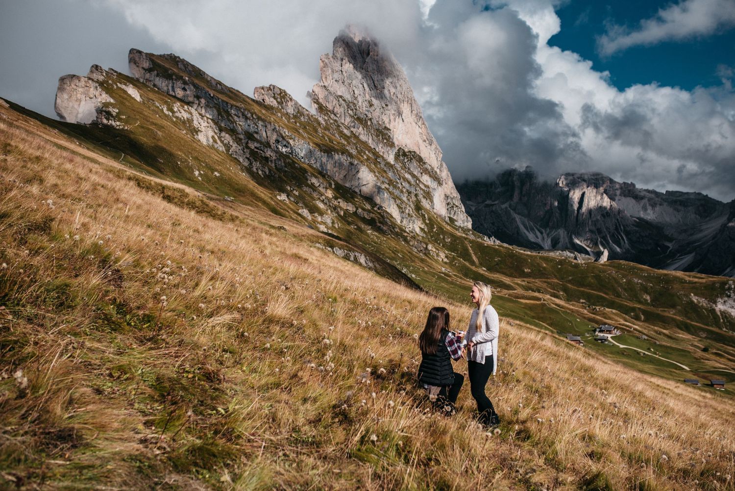 A same sex couple proposing at Seceda in the Dolomites in Italy as a photographer pretended to be a tourist to take photos.