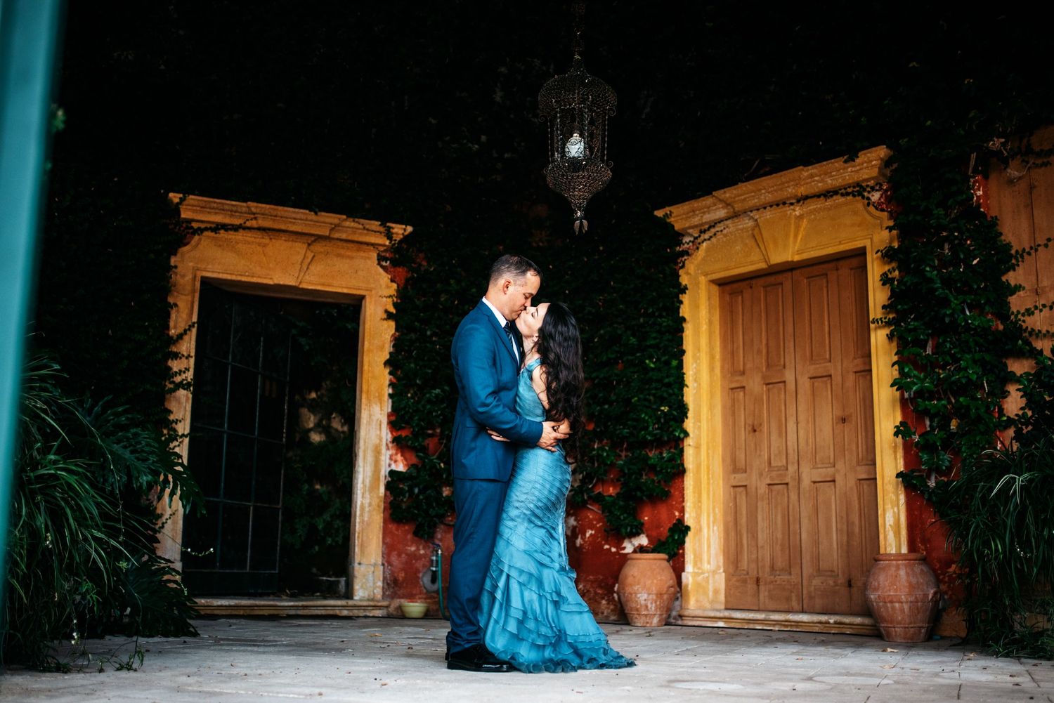 In home couple kissing with italian doors behind them in a villa, Vicenza, Italy.
